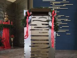 Kirchenpodium verkleidet mit grauem Stahl mit gelaserten Ausschnitten.
