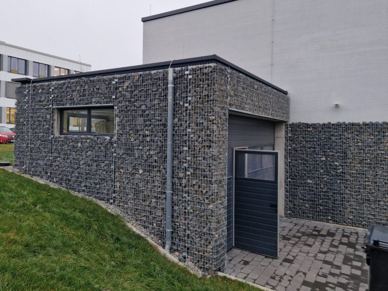 Gebäude mit Steinfassade in verzinkten Steinkörben und Garagentor.